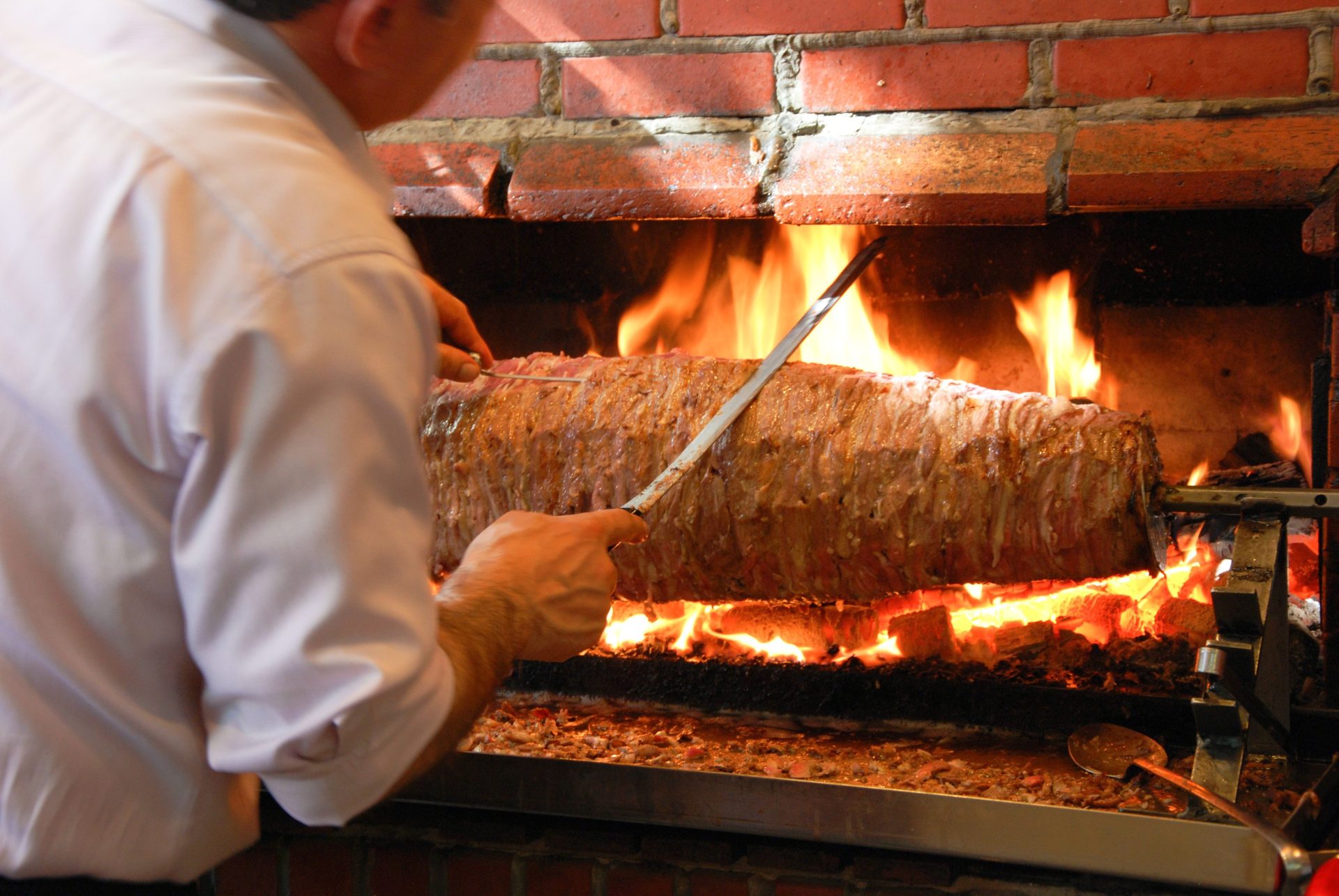 Ein Koch bereitet in Istanbul auf einem Grill mit offener Flamme traditionellen türkischen Döner Kebab zu.